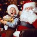 Santa Claus and shouting cute boy sitting in Christmas room with gifts. Christmas home decoration.